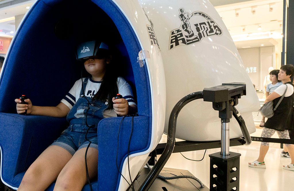 A little girl wears VR device to play games in a shopping